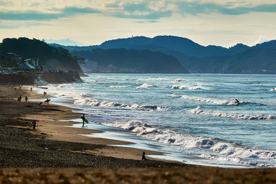 Scenic view of sea with silhouette people against sky in the morning
