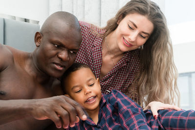 Mixed race family sitting in bed