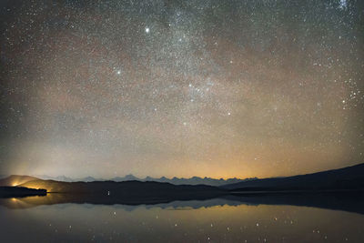 Scenic view of lake against sky at night