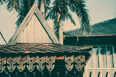 Low angle view of palm trees and building