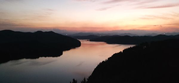 Scenic view of silhouette mountains against romantic sky at sunset