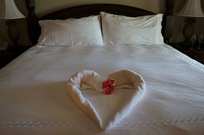 High angle view of heart shape towel on bed in hotel