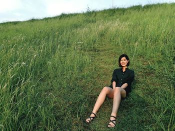 Young woman sitting on field
