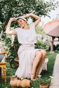 Woman sitting on chair against plants