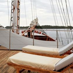 Sailboats moored in sea against sky