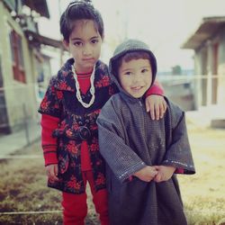 Portrait of sisters standing on field