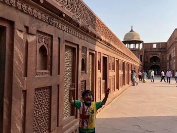 Portrait of boy with mouth open standing by building