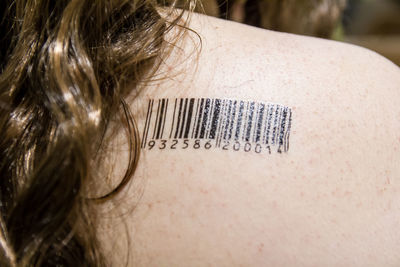 Close-up of woman with bar code on shoulder