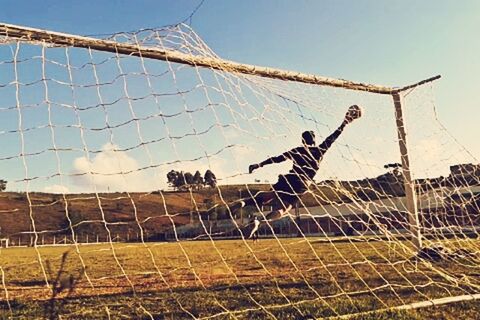 fence, field, sport, leisure activity, lifestyles, men, sky, chainlink fence, grass, day, protection, built structure, building exterior, clear sky, safety, full length, architecture, outdoors