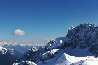 Scenic view of snow mountains against blue sky