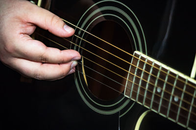 Midsection of man playing guitar