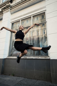 Full length of man jumping in city