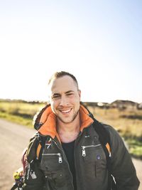 Portrait of smiling man standing against sky
