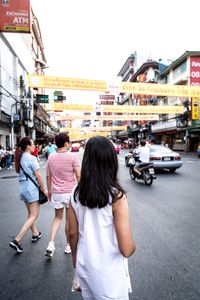 Rear view of woman walking on street in city