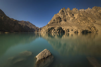 Panoramic view of lake and mountains against blue sky