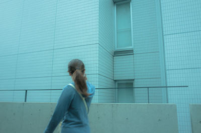 Close-up of woman standing against black background
