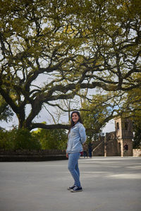 Portrait of boy standing by tree