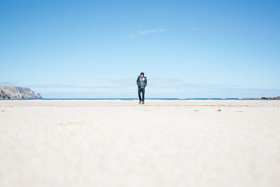 Full length of man standing at beach against sky