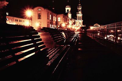 Empty road along buildings at night