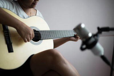 Midsection of woman playing guitar