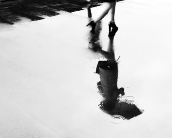 Low section of person walking on puddle