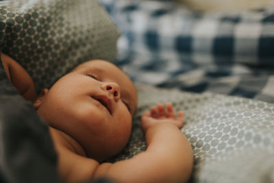 Baby boy lying on bed