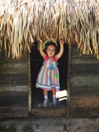 Portrait of girl standing at doorway in hut