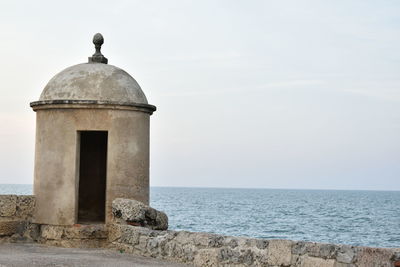 Gazebo by sea against sky