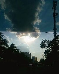 Road passing through city against cloudy sky