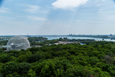 View of trees and buildings against cloudy sky