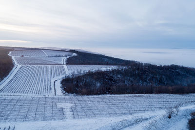 Snow covered land against sky