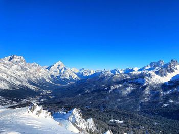 Scenic view of snowcapped mountains against clear blue sky