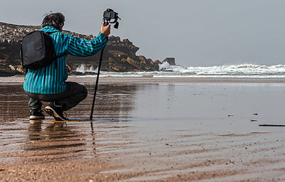 Side view of senior man on beach against sky