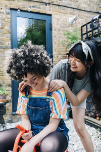 Full length of mother and daughter sitting outdoors