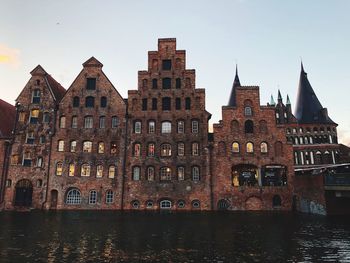 River by buildings against sky in city
