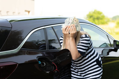 Rear view of woman holding car