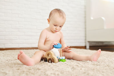 Portrait of cute baby boy sitting on floor