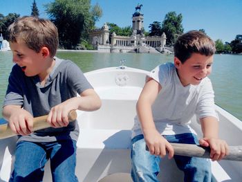 Happy friends sitting by water