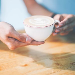 Cropped image of hand holding coffee cup