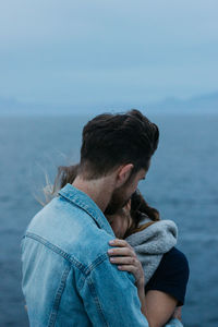 Rear view of man in sea against sky