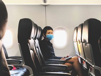 Rear view of man sitting in airplane