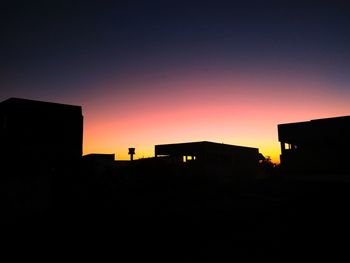 Silhouette buildings against sky during sunset