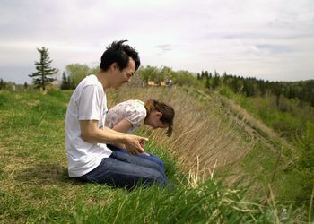 Young couple sitting on field