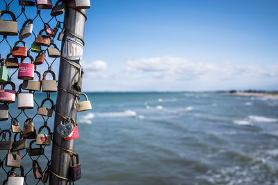 Close-up of padlocks hanging on sea