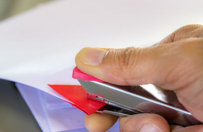 Close-up of cropped hand using stapler