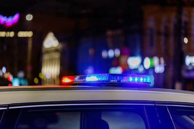 Police car lights at night in city with selective focus and bokeh blur