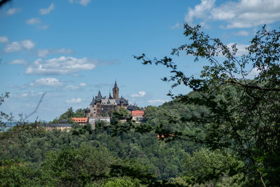 View of trees and building against sky