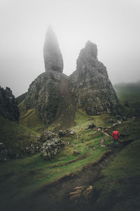 Rear view of man on rock against sky