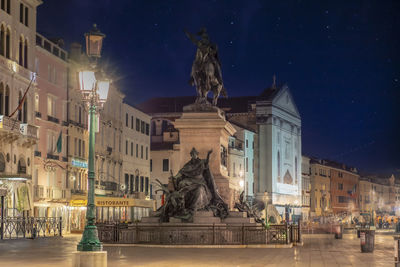 Statue in city at night