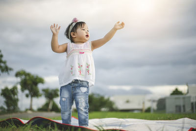 Full length of cute girl standing against sky